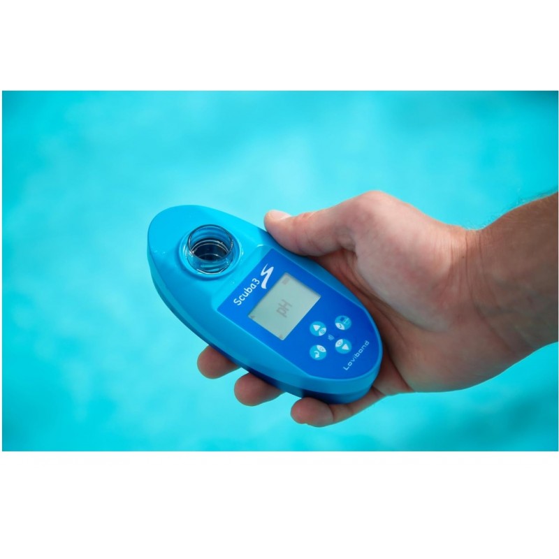 Mano sosteniendo un medidor digital de pH scuba 3 color azul sobre el agua de una piscina, utilizado para analizar la calidad del agua